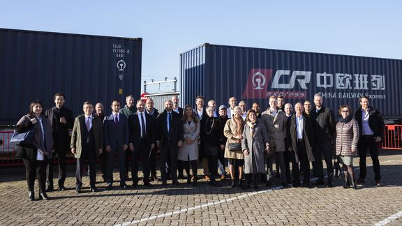 Workers pose in front of the rail shuttle