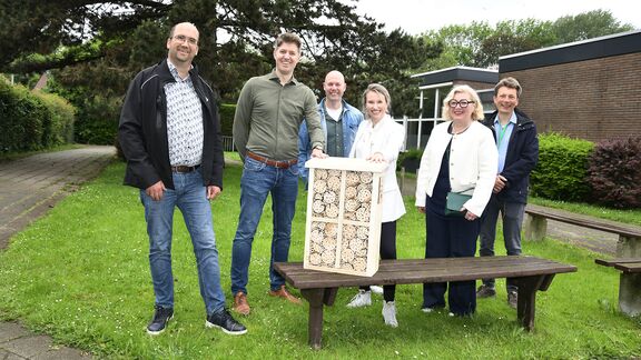 Deelnemers poseren met een bijenhotel bij een basisschool in Rozenburg