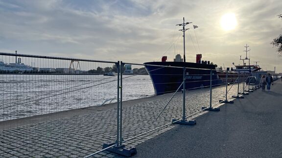 Wandelaars op de Parkkade lopen langs een aangemeerd schip