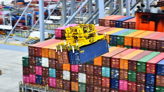 Containers are unloaded in pairs from the ship off the quay