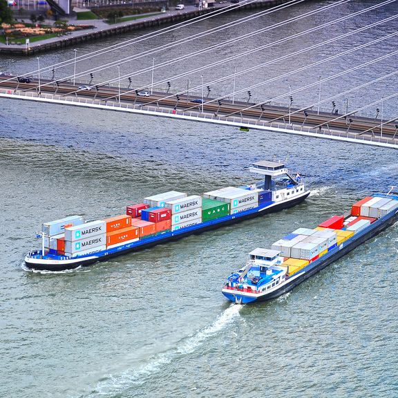 Containerbinnenvaartschepen passeren elkaar onder de Erasmusbrug